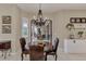 Cozy dining area with elegant chandelier, comfortable leather chairs, and sliding glass doors to the outdoor patio at 8449 Lone Eagle Way, Sarasota, FL 34241