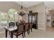 Elegant dining room with a large window, chandelier, and a dark wood table with seating for six at 8449 Lone Eagle Way, Sarasota, FL 34241