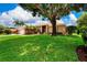 Charming home exterior boasts lush lawn, well-manicured landscaping, and classic architectural details at 8449 Lone Eagle Way, Sarasota, FL 34241