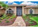 Inviting front entrance with double doors, brick walkway, and colorful landscaping at 8449 Lone Eagle Way, Sarasota, FL 34241