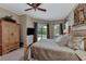 Comfortable main bedroom with a ceiling fan, neutral walls, and large windows overlooking the outdoor pool at 8449 Lone Eagle Way, Sarasota, FL 34241