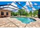Screened-in pool area features brick-paver flooring, a swimming pool, and ample patio seating at 8449 Lone Eagle Way, Sarasota, FL 34241