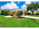 Beautiful home featuring a well-manicured lawn, mature trees, and a paved driveway at 8449 Lone Eagle Way, Sarasota, FL 34241