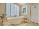 Elegant bathroom with a modern standalone tub and shuttered windows, providing a relaxing atmosphere at 8504 Woodbriar Dr, Sarasota, FL 34238