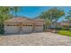 Spacious paver driveway and a three-car garage with attractive landscaping at 8504 Woodbriar Dr, Sarasota, FL 34238