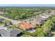 Aerial view showcasing the home's tile roof, backyard pool, and the surrounding neighborhood with lush greenery at 909 143Rd Ne St, Bradenton, FL 34212