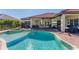 Backyard featuring a luxurious pool, spa, covered patio with an outdoor kitchen, and ample seating areas at 909 143Rd Ne St, Bradenton, FL 34212