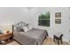 Bedroom featuring a metal bed frame with soft pillows, a bedside table, and a bright window at 909 143Rd Ne St, Bradenton, FL 34212