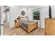 Bedroom featuring a wooden bed frame with cozy decor, a bedside table, and a window at 909 143Rd Ne St, Bradenton, FL 34212