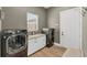 Efficient laundry room with granite countertops, white cabinets, modern washer and dryer, and access to the garage at 909 143Rd Ne St, Bradenton, FL 34212