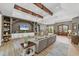 Bright, open-concept living room boasts hardwood floors, wooden beams, and an inviting gray sectional sofa at 909 143Rd Ne St, Bradenton, FL 34212