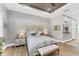 Comfortable main bedroom featuring neutral tones, wood floors, and a tray ceiling at 909 143Rd Ne St, Bradenton, FL 34212
