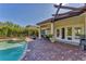 Relaxing patio area features a swimming pool, hot tub, tile pavers, covered dining, and double doors to the home at 909 143Rd Ne St, Bradenton, FL 34212