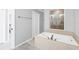 Large soaking tub in the primary bath, tile flooring, and frosted glass windows for natural light at 9203 Griggs Rd # B102, Englewood, FL 34224