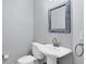 Stylish half bathroom with a pedestal sink, framed mirror, and modern fixtures at 9203 Griggs Rd # B102, Englewood, FL 34224