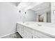 Bathroom with a double sink vanity, large mirror, neutral color palette, and ceiling fan at 9203 Griggs Rd # B102, Englewood, FL 34224