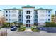 Exterior view of condo building featuring neutral paint, multiple balconies, and assigned parking spots at 9203 Griggs Rd # B102, Englewood, FL 34224