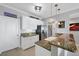 Kitchen with granite countertops, stainless steel appliances, white cabinets, and pendant lighting at 9203 Griggs Rd # B102, Englewood, FL 34224