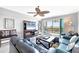 Comfortable living room with modern furniture, a ceiling fan, and sliding glass doors to the balcony at 9203 Griggs Rd # B102, Englewood, FL 34224