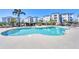 Inviting community swimming pool with lounge chairs and lush landscaping for relaxation by the building at 9203 Griggs Rd # B102, Englewood, FL 34224