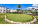 Community putting green surrounded by lush landscaping and well-maintained grounds in the community at 9203 Griggs Rd # B102, Englewood, FL 34224