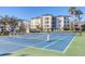 Community tennis court surrounded by lush landscaping and well-maintained grounds in the community at 9203 Griggs Rd # B102, Englewood, FL 34224