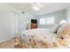 Bright bedroom features a coastal-themed quilt, ceiling fan, and an attached bathroom for added convenience at 9619 Valencia Cv, Bradenton, FL 34210