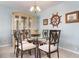 Elegant dining room with glass table, upholstered chairs, and display cabinet at 9619 Valencia Cv, Bradenton, FL 34210