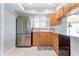Modern kitchen with stainless steel refrigerator, wood cabinets, and tile flooring at 9619 Valencia Cv, Bradenton, FL 34210