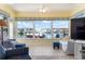 Bright sunroom with panoramic windows offering waterfront views and cozy seating arrangements at 9619 Valencia Cv, Bradenton, FL 34210