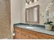 Bathroom featuring a vanity with a marble countertop, decorative mirror, and a tiled shower at 1110 79Th E St, Palmetto, FL 34221