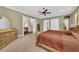 Bedroom featuring a four-poster bed, carpeted floors, white closets, and adjacent hallway at 1110 79Th E St, Palmetto, FL 34221