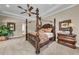 Main bedroom featuring a four-poster bed, tray ceiling, and view into the en suite bath at 1110 79Th E St, Palmetto, FL 34221