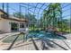 An enclosed backyard pool features a tranquil waterfall, rock features, and beautiful surrounding tropical plants at 1110 79Th E St, Palmetto, FL 34221