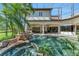 An eye-level shot displays a backyard pool with a rock waterfall, tropical foliage, and a screened enclosure at 1110 79Th E St, Palmetto, FL 34221