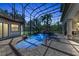 Twilight view of the screened-in pool, highlighting the spa and rock waterfall feature at 1110 79Th E St, Palmetto, FL 34221