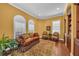 Sitting room featuring a yellow wall, ornate sofa, decorative rug, and arched windows with shutters at 1110 79Th E St, Palmetto, FL 34221