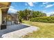 A backyard featuring a screened-in lanai, green lawn, and mature trees, perfect for outdoor living at 1118 Deardon Dr, Venice, FL 34292