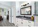 Stylishly appointed bathroom featuring a white vanity with black hardware and tile flooring at 1118 Deardon Dr, Venice, FL 34292