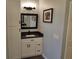 Bathroom featuring a black granite countertop, vanity, mirror, and white cabinets at 1118 Deardon Dr, Venice, FL 34292