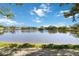 Scenic view of a tranquil lake surrounded by lush greenery under a bright, partly cloudy sky at 1118 Deardon Dr, Venice, FL 34292