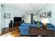 Cozy living room featuring wood floors, a plush blue sofa, and recessed lighting at 1118 Deardon Dr, Venice, FL 34292