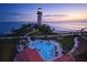 Aerial view of a Lighthouse adjacent to a pool overlooking the ocean at dusk at 15916 Sugar Hill Dr, Punta Gorda, FL 33982