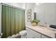 Stylish bathroom featuring a decorative green shower curtain and granite countertop vanity at 15916 Sugar Hill Dr, Punta Gorda, FL 33982