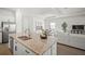 Modern kitchen featuring stainless steel appliances and an island with barstool seating that flows into the living area at 15916 Sugar Hill Dr, Punta Gorda, FL 33982