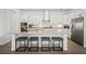 A modern kitchen features an island with barstool seating, stainless appliances, and white cabinetry at 15916 Sugar Hill Dr, Punta Gorda, FL 33982