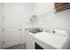 Efficient laundry room featuring granite countertops, washer, dryer, and overhead shelving for storage at 15916 Sugar Hill Dr, Punta Gorda, FL 33982