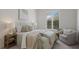 Inviting bedroom featuring a cozy chair and large window with plantation shutters at 16734 Collingtree Xing, Lakewood Ranch, FL 34202