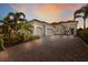 Charming home with a three-car garage, paver driveway, and tropical landscaping at 16734 Collingtree Xing, Lakewood Ranch, FL 34202