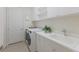 Well-lit laundry room with washer and dryer, storage cabinets and utility sink at 16734 Collingtree Xing, Lakewood Ranch, FL 34202